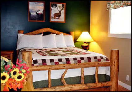 Comfortable queen bed with country ambiance in the Deer-Elk Room.