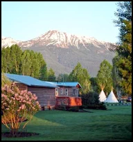 Views of lush lawn, tepees and mountains from the Red Rooster Suite private deck.